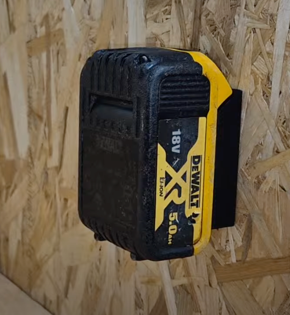 Mounted DeWalt battery on a black battery holder on wooden background
