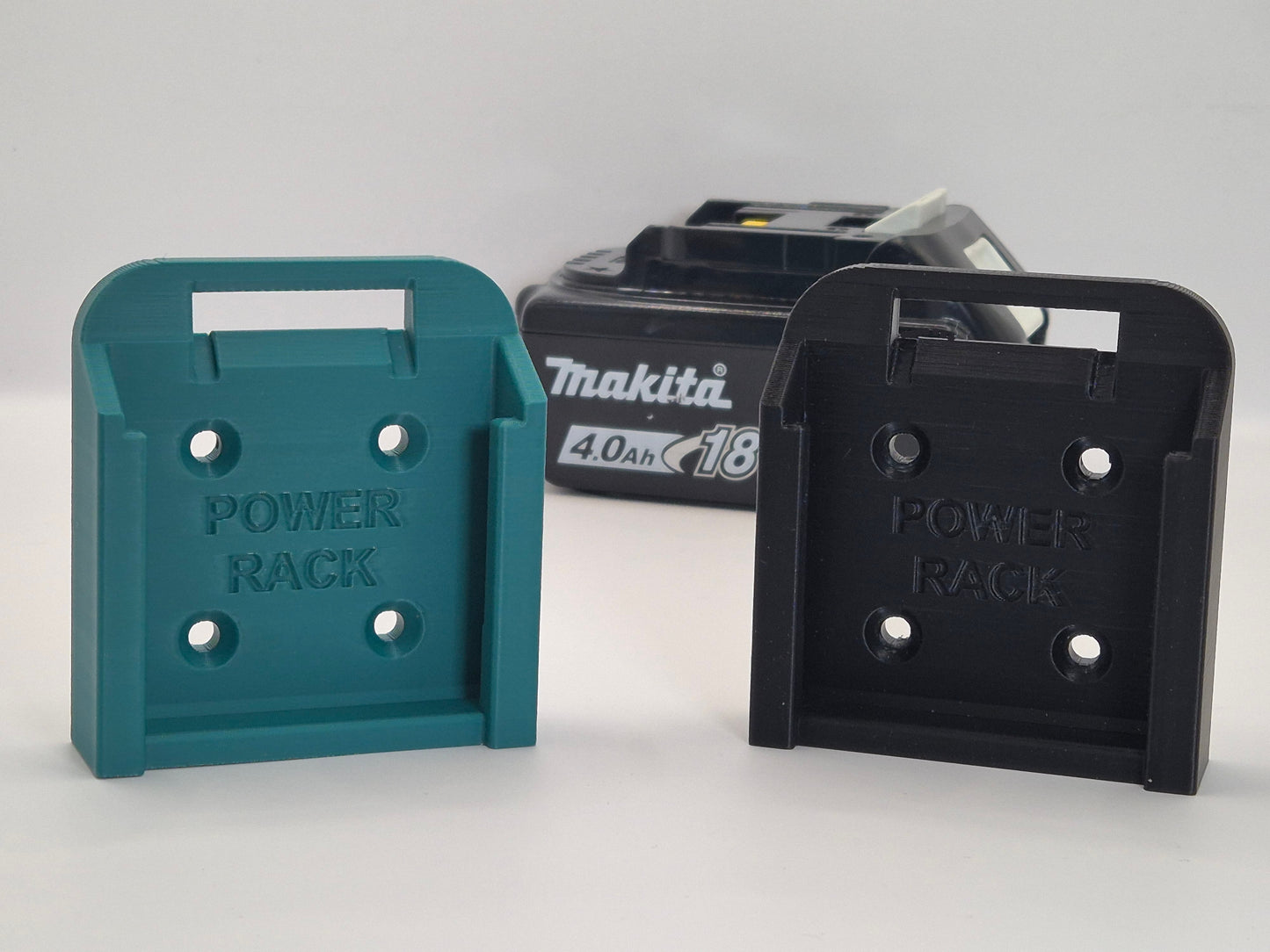 Two power rack battery holders, one Makita blue and one black, with a Makita battery in the background on a light gray background.