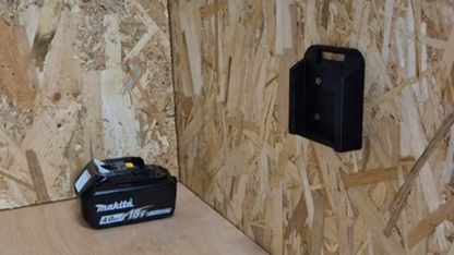 Black battery holder on a wooden panel background