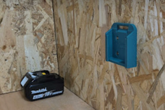 Blue battery holder on a wooden panel background