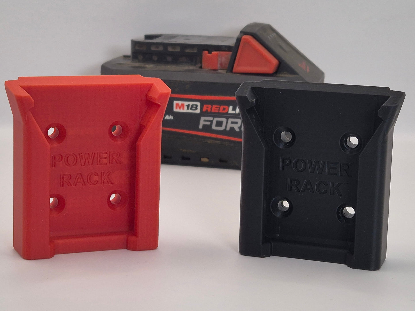 Red and black power rack Milwaukee Battery holders with a battery in the background on a light grey background