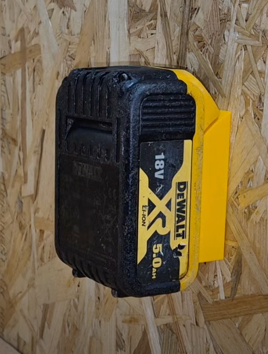 Mounted DeWalt battery on a yellow battery holder on wooden background