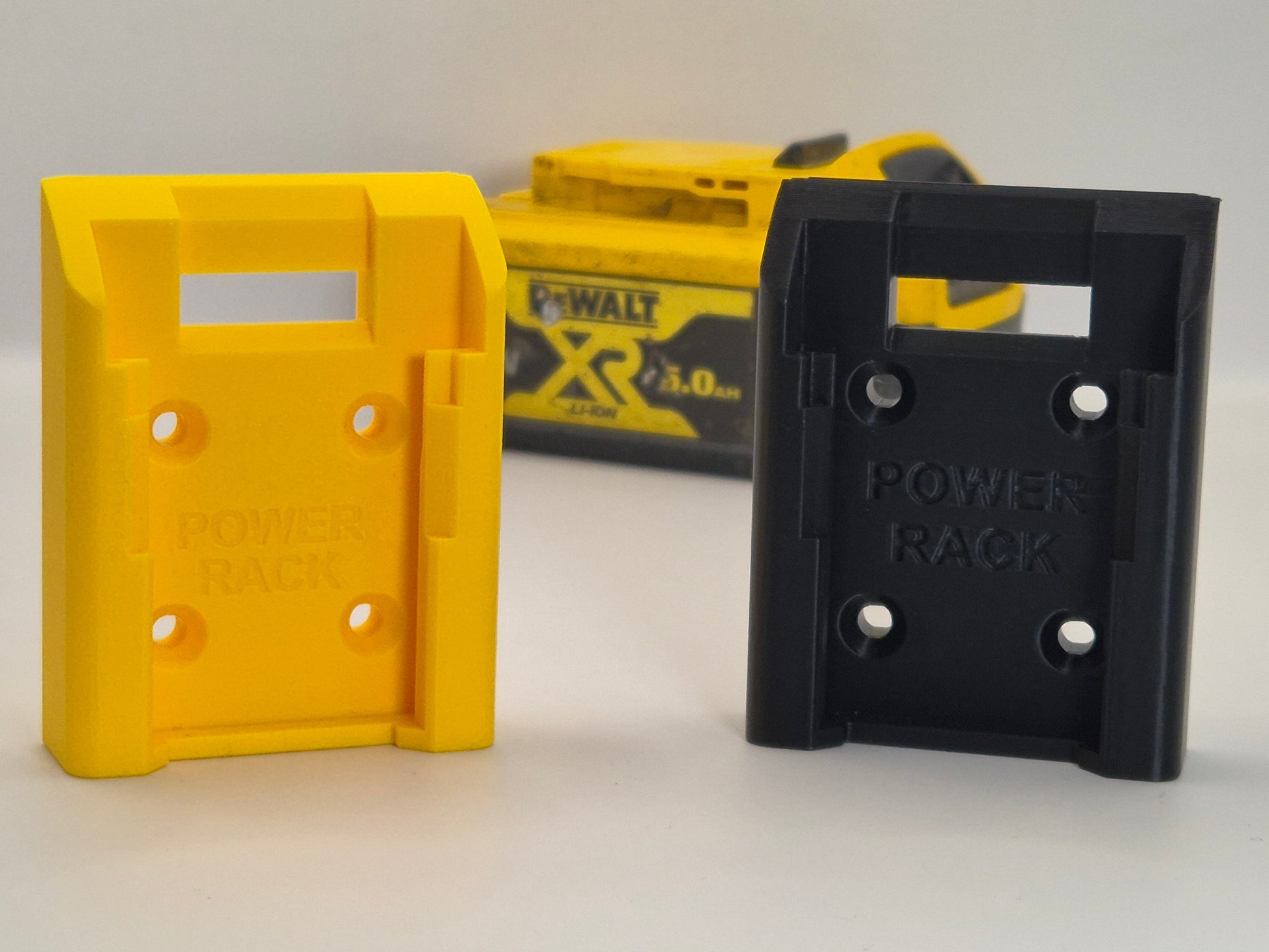 Yellow and black Power Rack battery mounts on a white background with a DeWalt battery in the background.